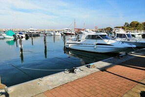 A marina with boats docked, a clear sky, and a calm water surface. - Holiday home Cormorant (Glowe)