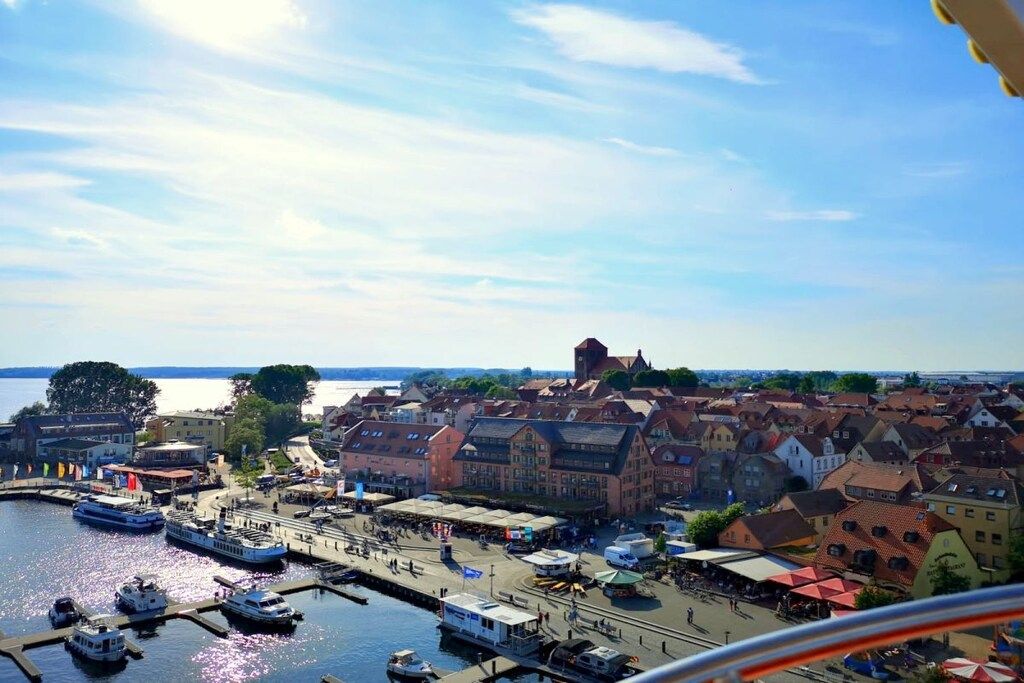 Une ville côtière dotée d’un port de plaisance, de bâtiments historiques et d’une tour imposante.