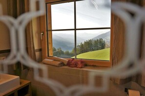 Ein Badezimmer mit einem großen Fenster, einem Handtuch und einer Badmatte.