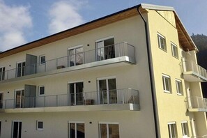 A multi-story building with balconies, windows, and a wooden roof. - Schuster's Alpine Panorama (Seewiesen)