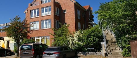A multi-story brick building with a staircase leading to an upper entrance.