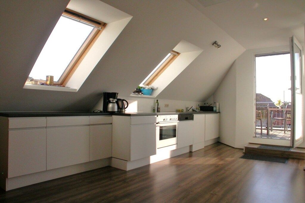 A modern kitchen with skylights, a built-in oven, and a view of the outdoors.
