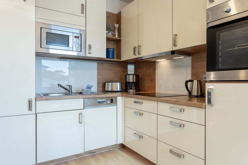 A modern kitchen with a microwave, coffee maker, and oven.