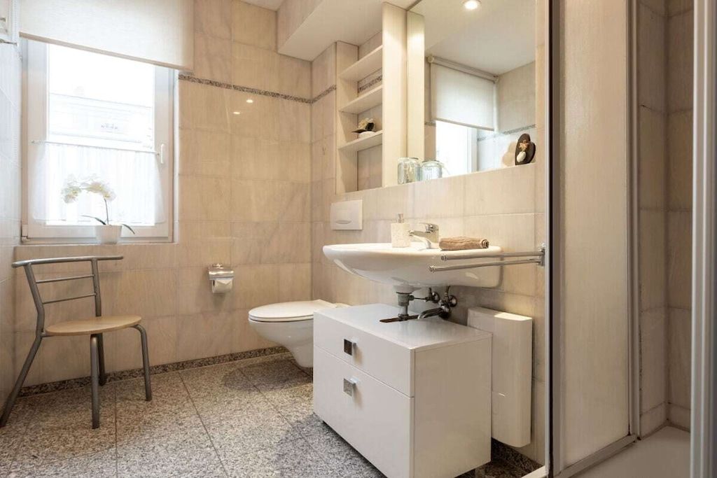 A modern bathroom with a toilet, sink, and shower area.