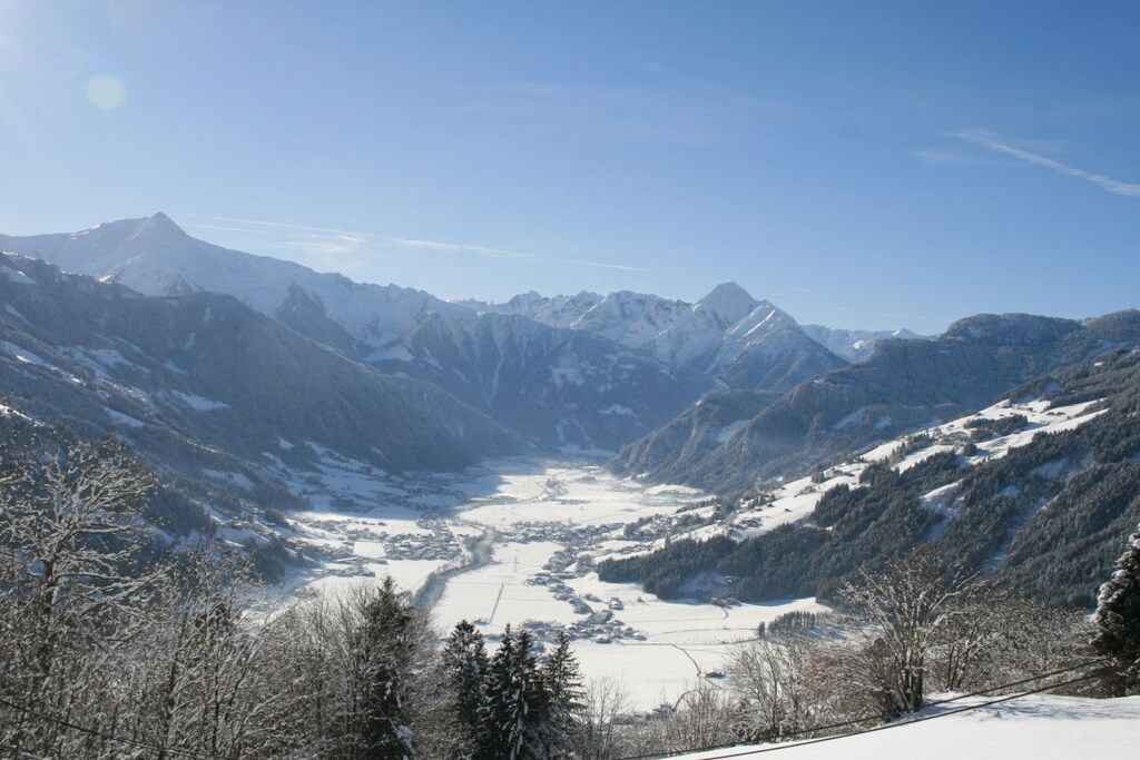 Eine gebirgige Landschaft mit einem Tal und verschneitem Gelände.