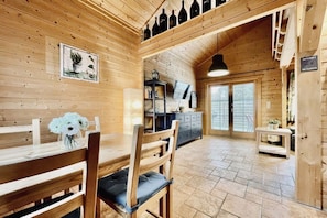 A wooden interior with a dining area, a kitchen, and a living space. - Log cabin Seagull's nest (Dierhagen)
