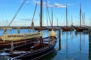 A marina with several boats docked, one with a banner reading 'OSTSEEBAD DERHAGEN'. - Log cabin Seagull's nest (Dierhagen)
