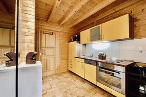 A kitchen with wooden cabinets, a stainless steel oven, and a sink. - Log cabin Seagull's nest (Dierhagen)