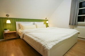 A bedroom with a bed, bedside tables, lamps, and a window. - Captain Pahlen Maisonette (Zingst)
