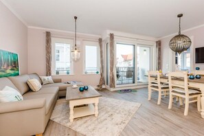 Un salon comprenant un canapé, une table basse et un coin repas avec des chaises et une table.