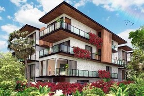 A multi-story residential building with balconies, large windows, and a garden area with red flowers. - Luxury & Serenity 2bd apt retreat, 1 km from beach (tulum)