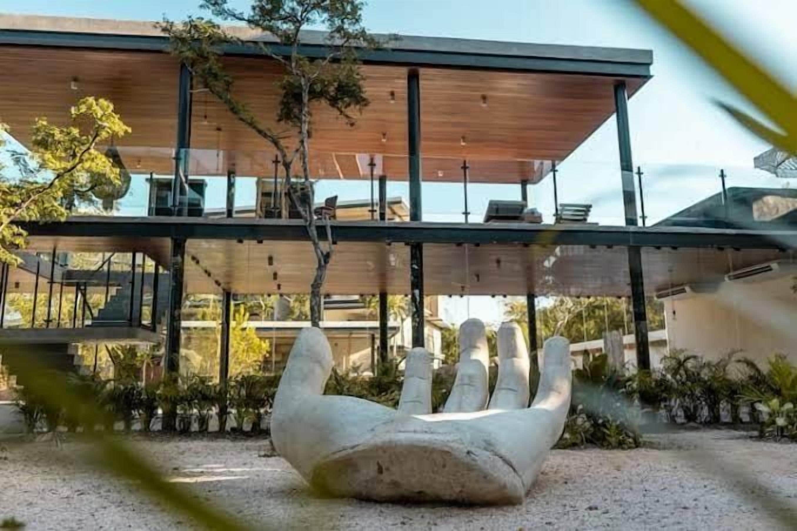 A modern building with a unique architectural design, featuring a large, abstract sculpture in the foreground.