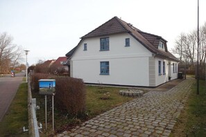 Ein zweistöckiges Haus mit Ziegeldach, befestigter Auffahrt und Briefkasten.
