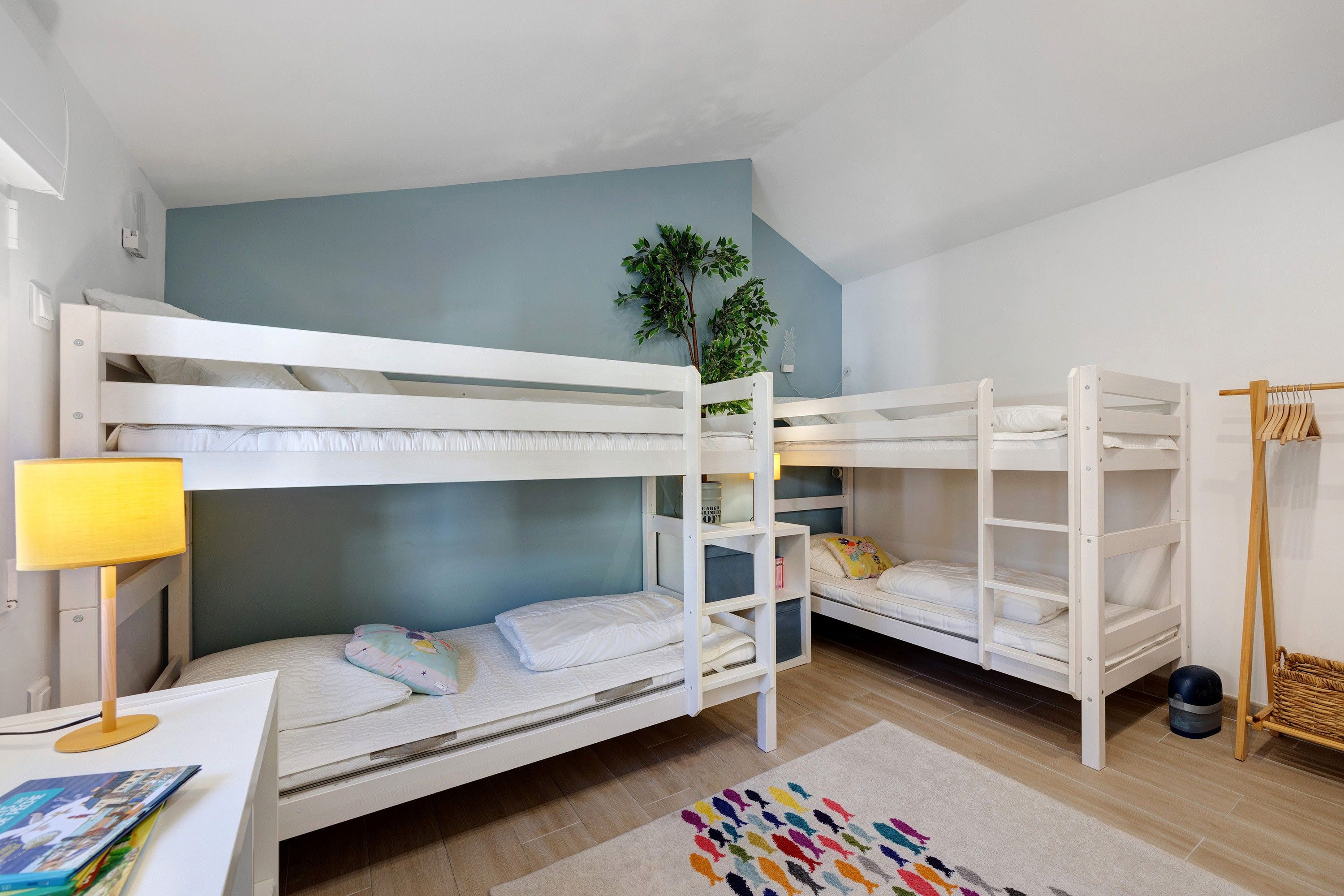 Habitación con literas, escritorio, lámpara y una alfombra colorida.