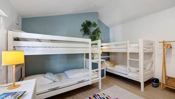 Habitación con literas, escritorio, lámpara y una alfombra colorida.