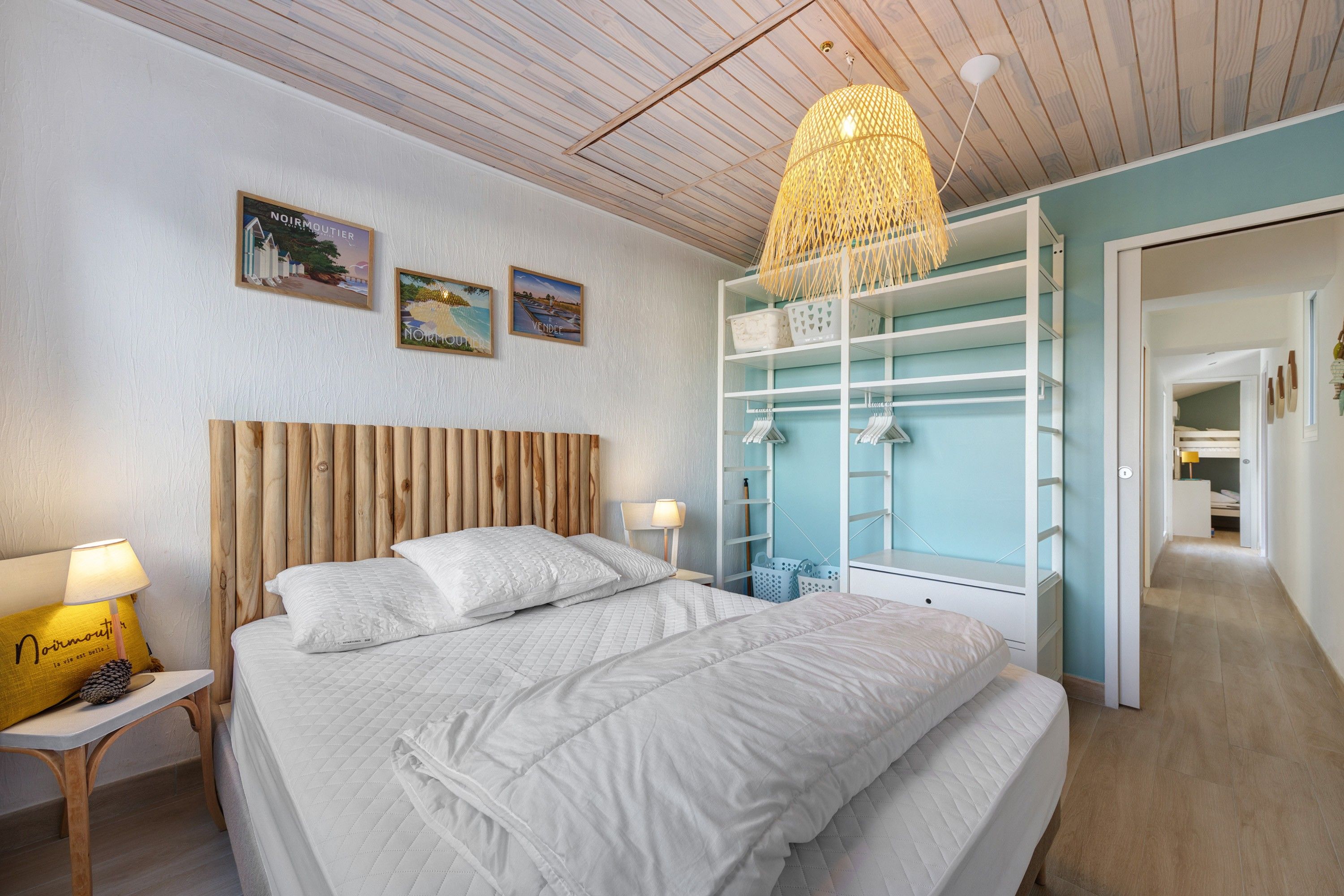 Een slaapkamer met een bed, een nachtkastje, een lamp, een kledingkast en een hanglamp.