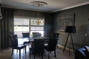 A dining area with a chandelier, a table with chairs, and a floor lamp. - Holiday home with 1 bedroom (Fuhlendorf)