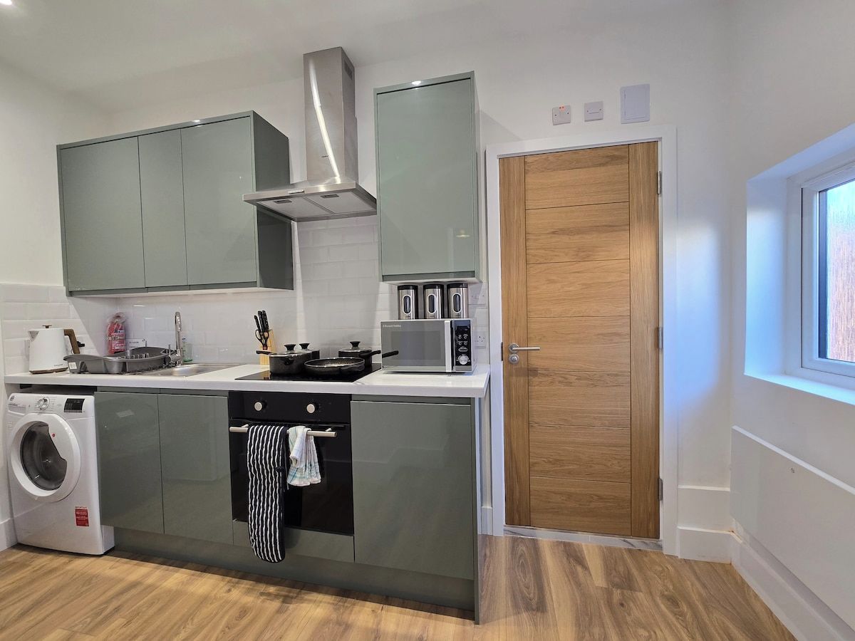 A compact kitchen with a built-in washing machine, a microwave, and a stove.