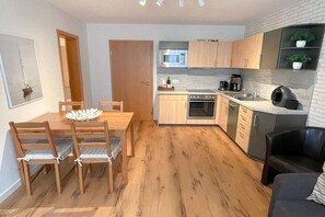 Eine kleine Küche mit Holzausstattung, einer Mikrowelle und einer Kaffeemaschine.