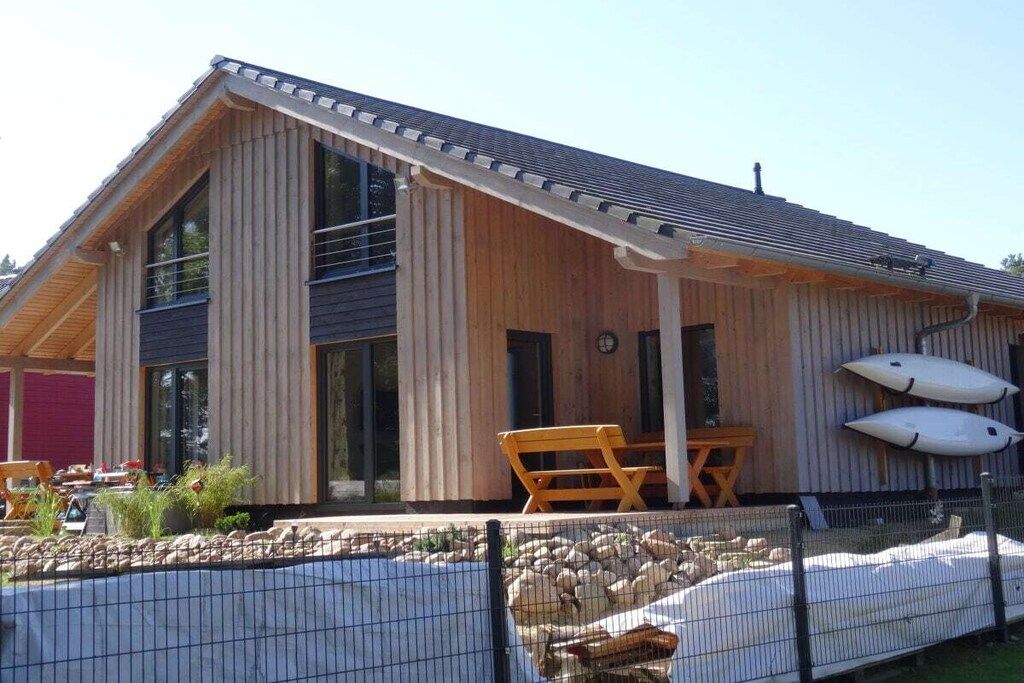 Une cabane en bois dotée d’un patio couvert, d’une piscine et de deux kayaks.