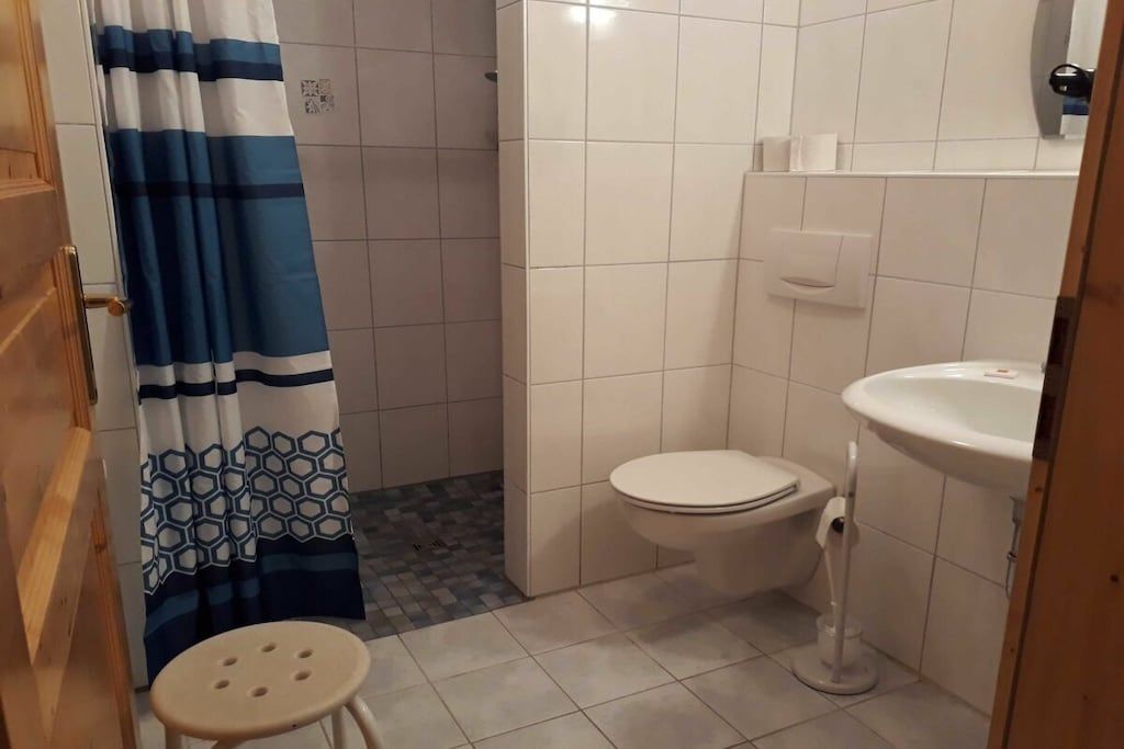 Ein kleines Badezimmer mit Toilette, Waschbecken und Duschvorhang.
