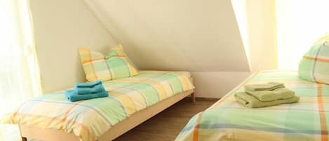 Un dormitorio con dos camas, cada una con cubrecama y almohadas a cuadros.