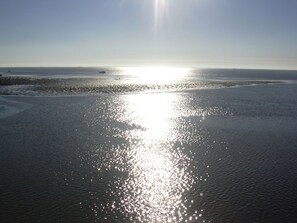 A beach with sunlight reflecting off the water. - Dream Berth Boatswain (Wittmund)