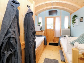 Ein Zimmer mit zwei Betten, Fernseher, Mikrowelle und einem fensterbepflanzten Fenster.