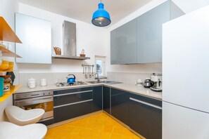 A modern kitchen with a sink, stove, and cabinets. - La Terrazza nel Blu | Sea View (Piano di Sorrento)
