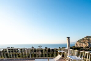 A terrace with a view of the sea and a lighthouse, featuring white railings and sun loungers. - La Terrazza nel Blu | Sea View (Piano di Sorrento)