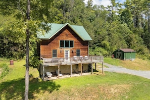 A wooden cabin with a porch, surrounded by trees. - Escape to 8 private acres in Floyd County with Little River views and direct private river access. Enjoy fishing, kayaking, private trails, high-speed WiFi, a dedicated workspace, a kids' area and plenty of room to relax in nature. (Floyd)