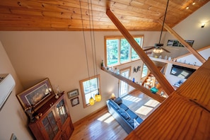 A spacious loft with a high ceiling, wooden beams, a loft bed, a dining area, and a view of the outdoors. - Escape to 8 private acres in Floyd County with Little River views and direct private river access. Enjoy fishing, kayaking, private trails, high-speed WiFi, a dedicated workspace, a kids' area and plenty of room to relax in nature. (Floyd)