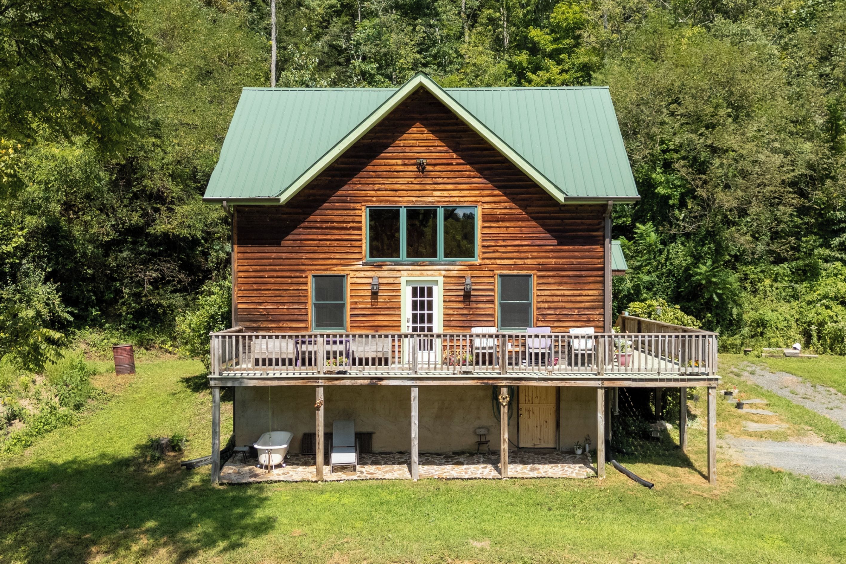 A wooden cabin with a balcony, a front door, and a small porch area.