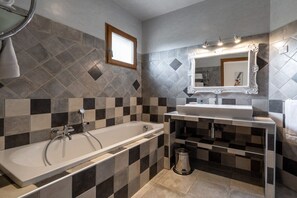 Ein Badezimmer mit einer Badewanne, einem Waschbecken und einem Spiegel.