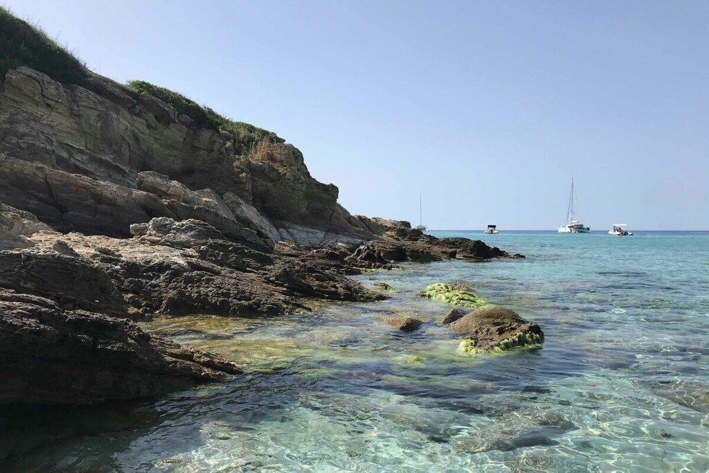 A coastal landscape with rocky terrain and clear water.