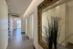 A hallway with a large mirror, a plant, and a door leading to another room. - Domus Rubina - terrace sea view (Sorrento)