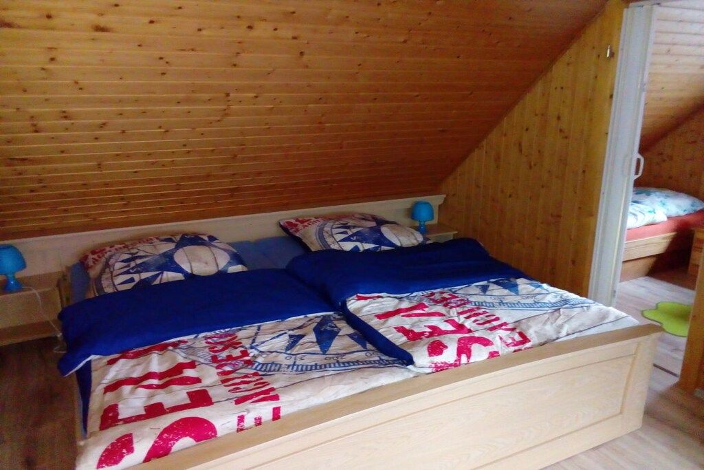 Una cama litera de madera con colcha y almohadas de diseño azul y blanco.