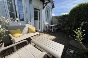 An outdoor patio area with a sofa, a small table, and a chair. - Holiday home with 1 bedroom (Blonville-sur-Mer)