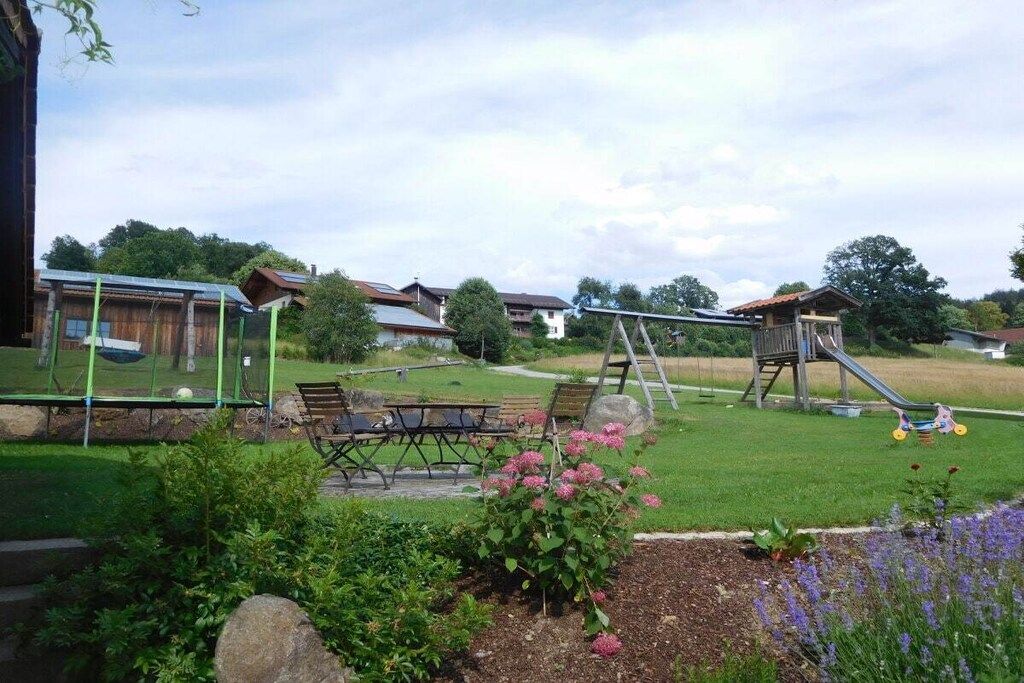 Zona exterior residencial con un arenero, una mesa de picnic y un jardín.
