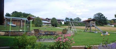Zona exterior residencial con un arenero, una mesa de picnic y un jardín.
