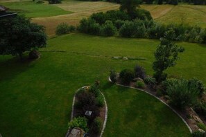 Jardí paisatjístic amb un camí corbat, una petita construcció i vegetació circumdant.