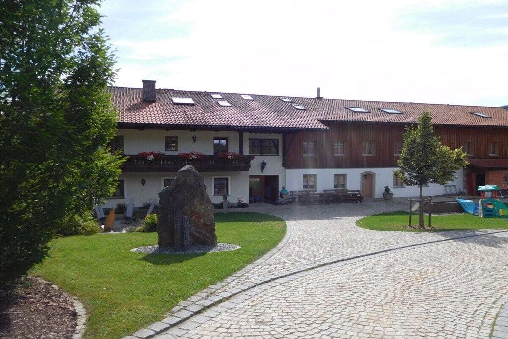 Un edificio con techo de tejas, un sendero de piedra y un área verde.