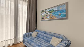 Une pièce avec un canapé, un tableau et une fenêtre avec des rideaux.
