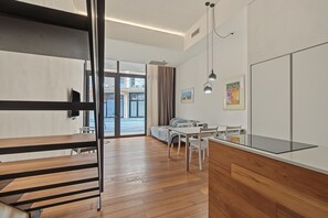 Habitación moderna con cama, escritorio y silla. Se observa una ventana con cortinas, un cuadro en la pared y una lámpara en el techo.