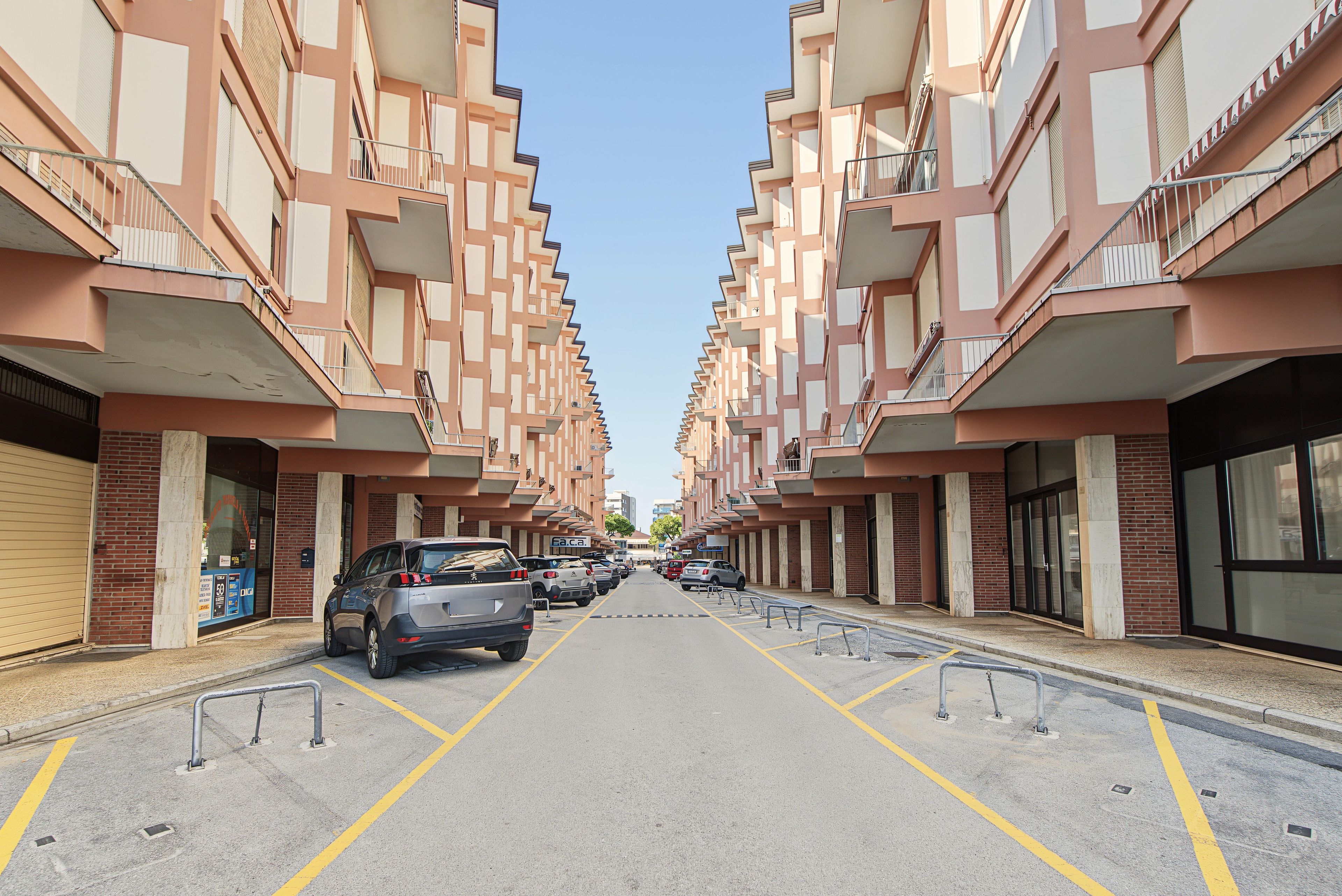A row of modern apartment buildings with a central road.