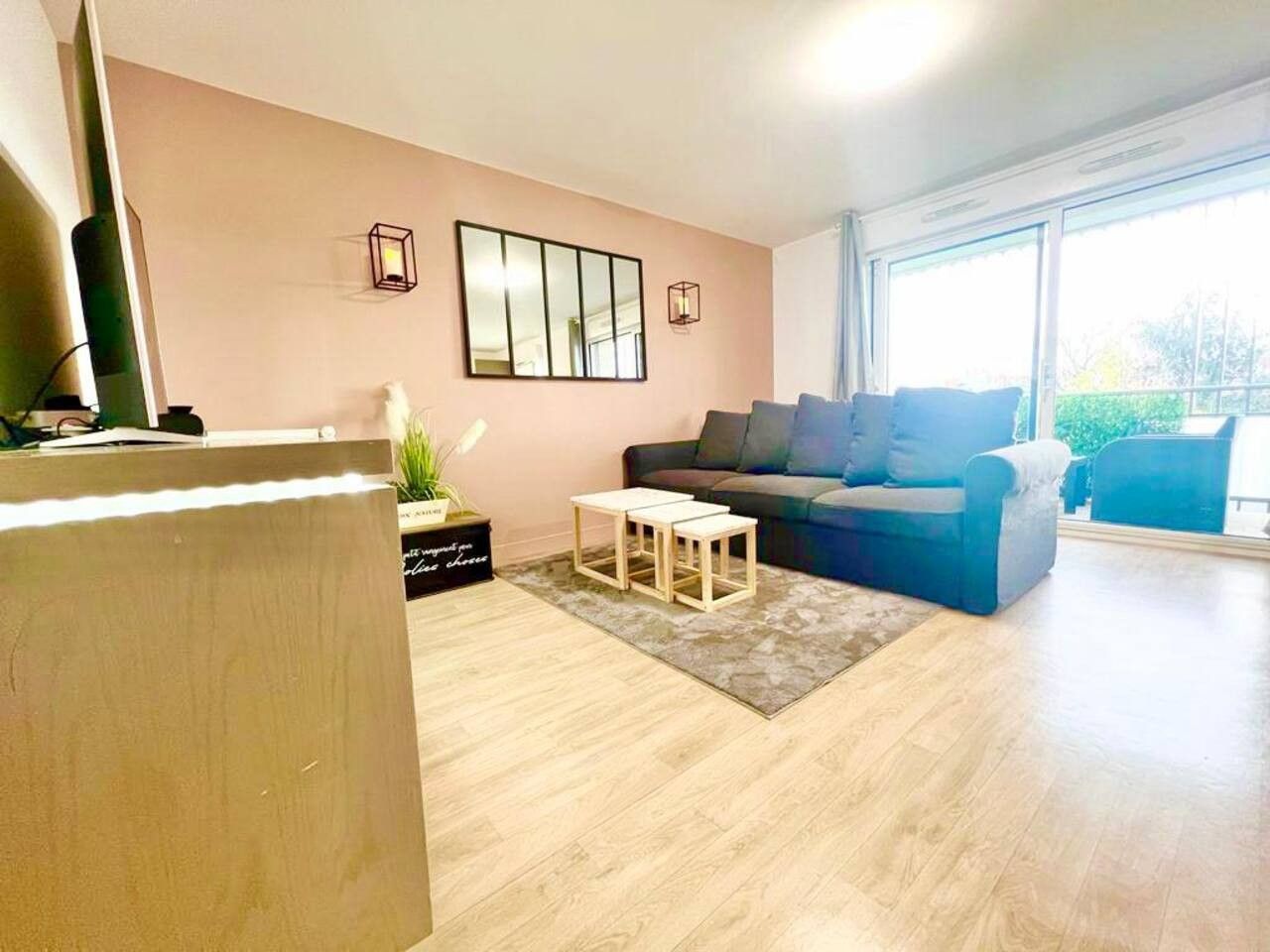 Een woonkamer met een bank, een salontafel en een flatscreen televisie.