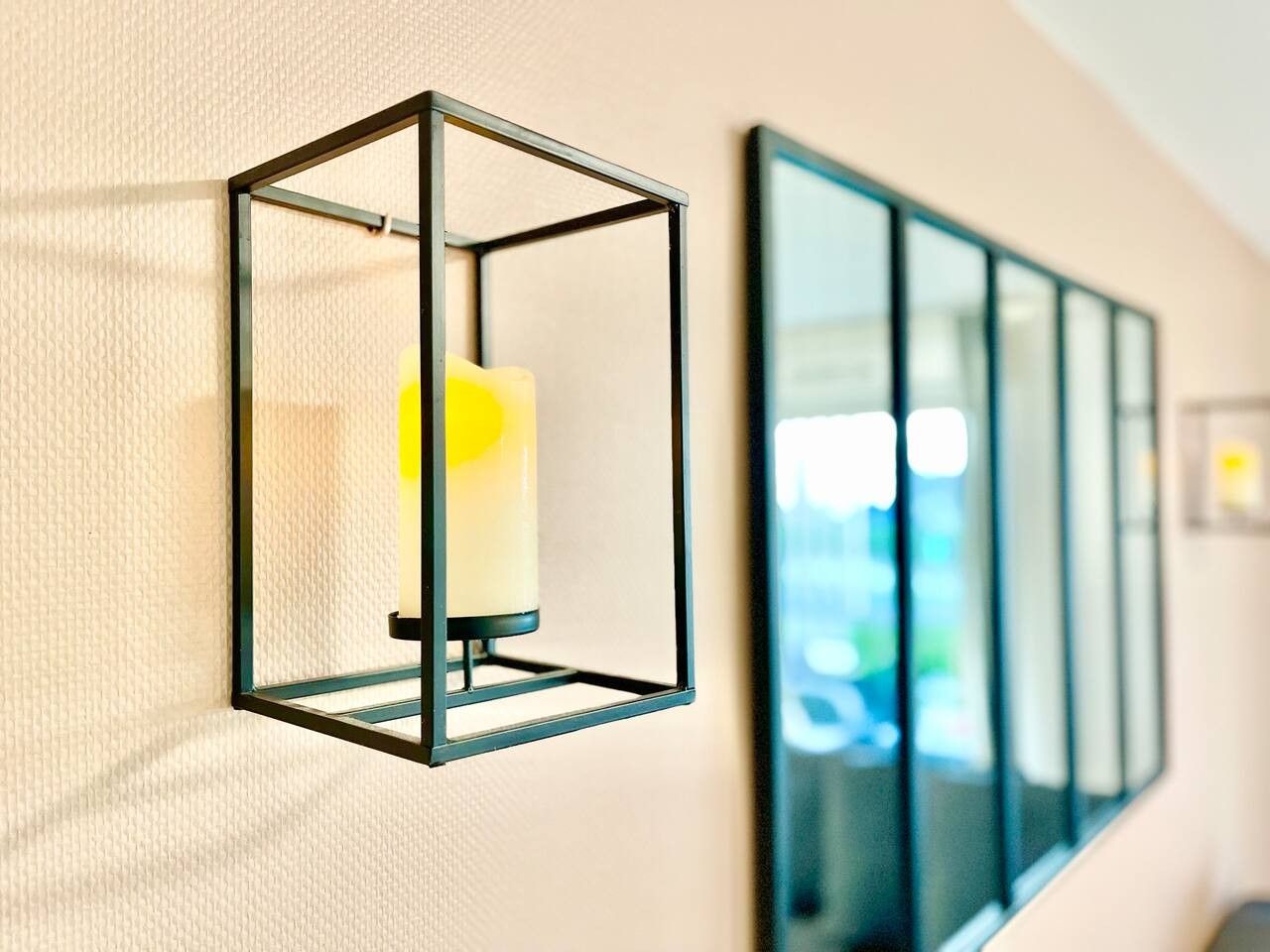 A wall-mounted light fixture with a candle inside.
