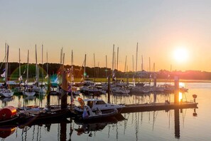 A marina with multiple boats docked at the pier during sunset.