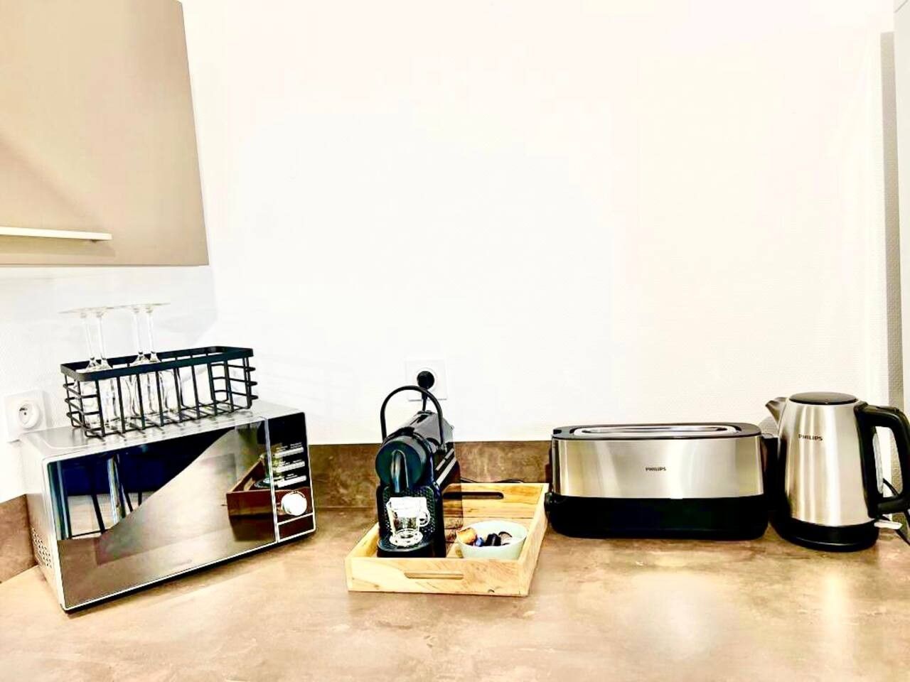 A kitchen with a toaster, a coffee maker, and a kettle.