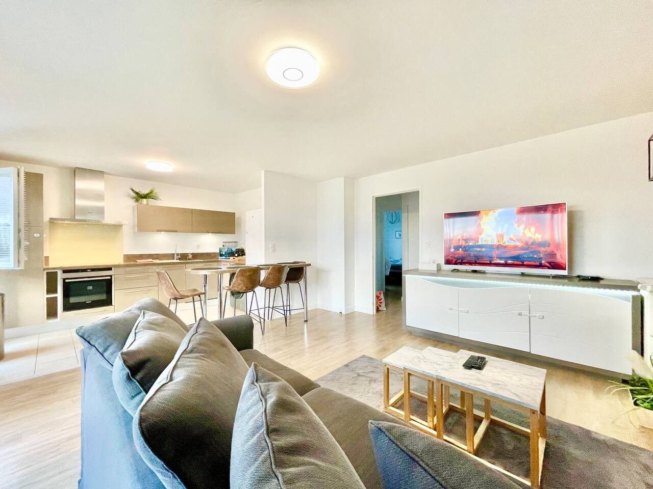 A modern living room with a sofa, a coffee table, and a television.